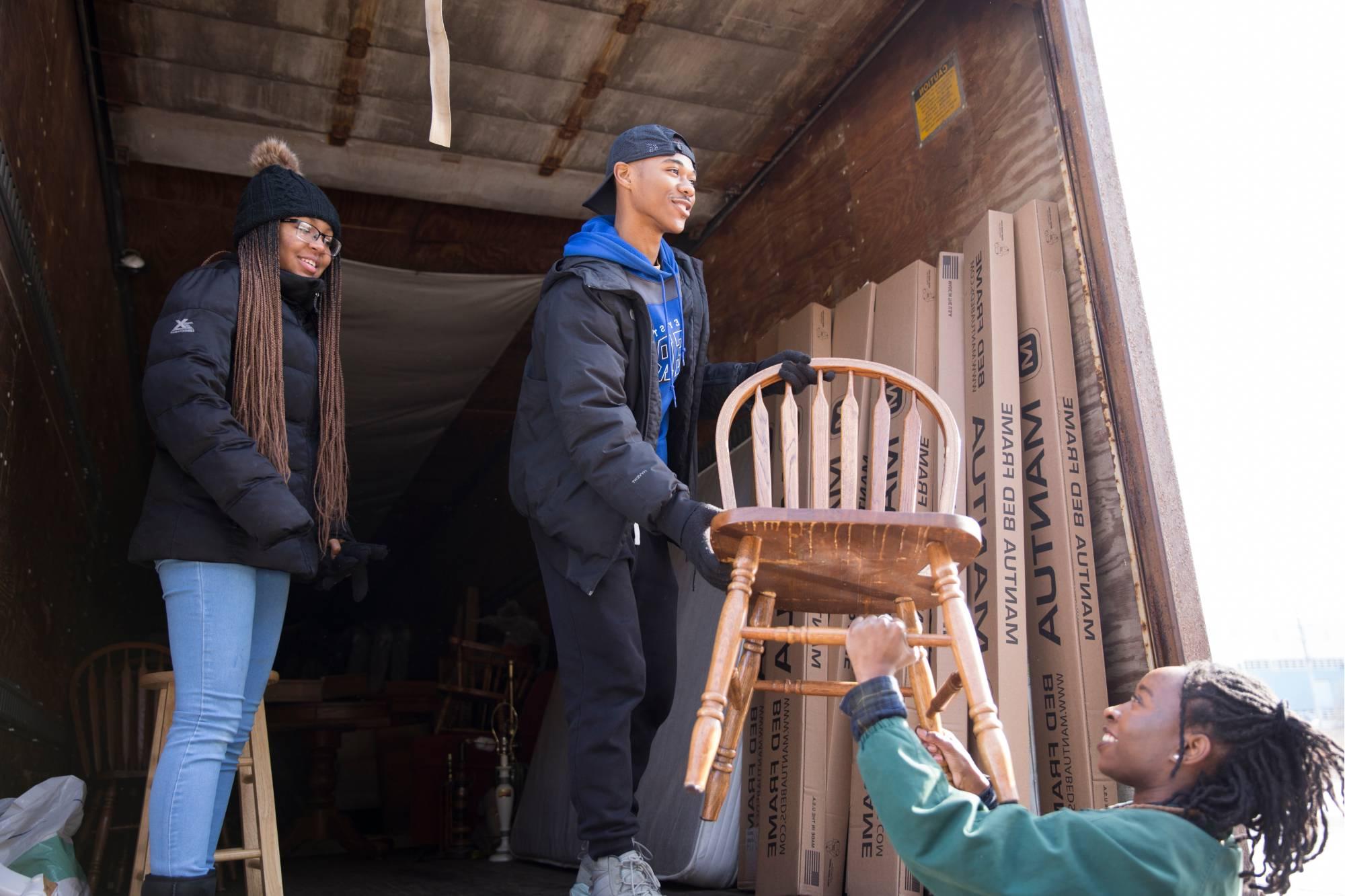 Students helping to move items from a truck